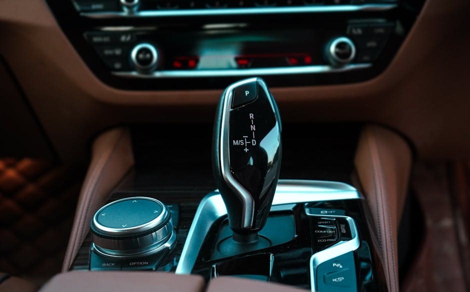 Close-up view of a modern car interior featuring a sleek gear lever and control panel. Ideal for automotive themes.