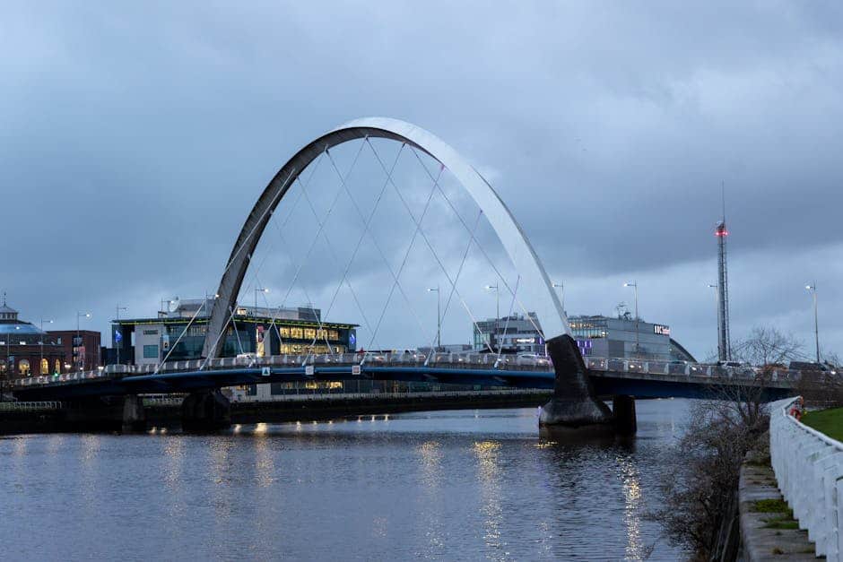 The illuminated Clyde Arc Bridge reflecting on the River Clyde at night in Glasgow, Scotland.