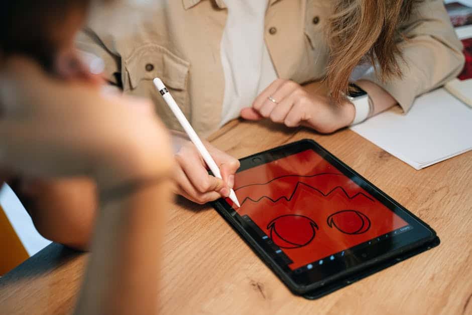 A person creatively designs a Halloween-themed illustration on a tablet using an Apple Pencil. Indoors setting.