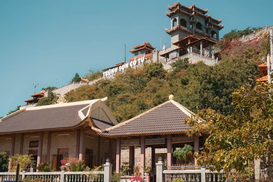 Trung Son Co Tu Pagoda on a sunny hillside, showcasing traditional architecture and vibrant natural surroundings.