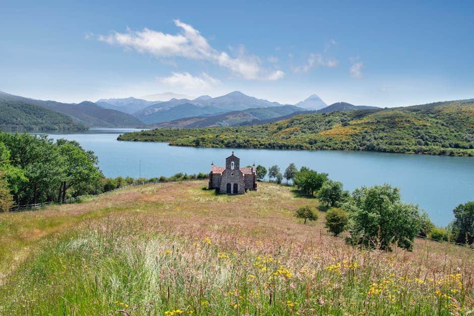 Majestic view of a stone building by a lake in Riaño, Spain.