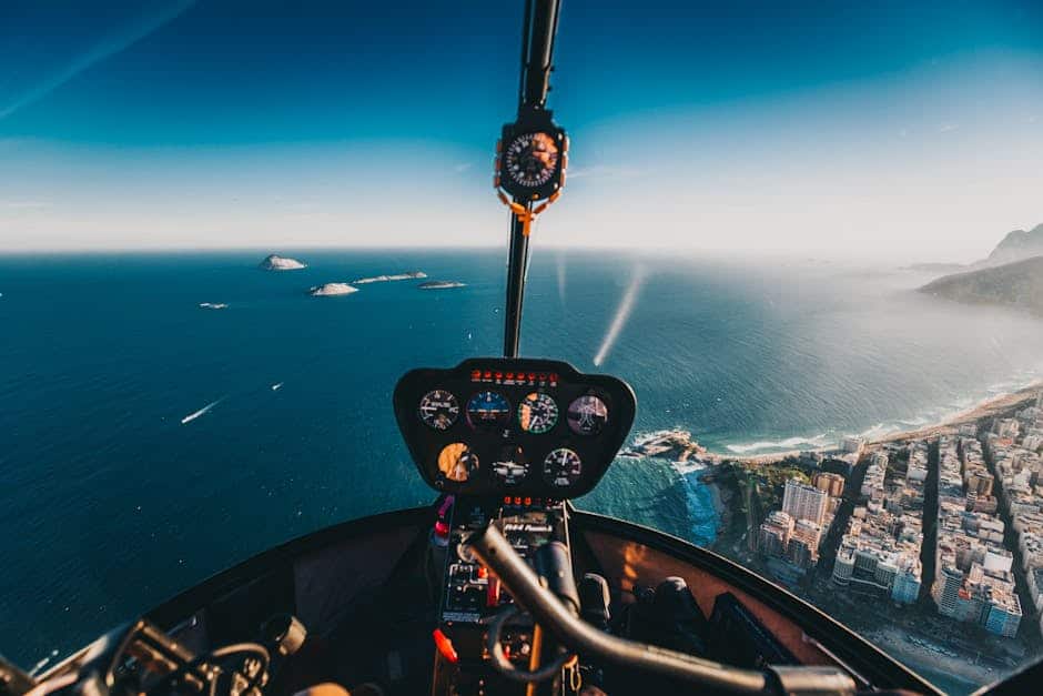 Aerial view from helicopter cockpit over Rio de Janeiro coastline and ocean.