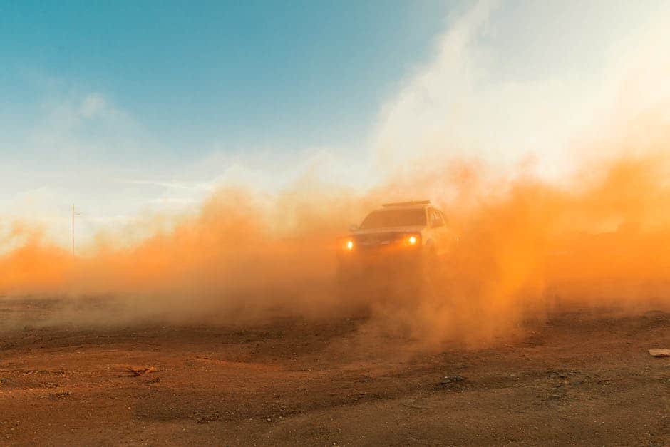 A rugged off-road vehicle kicks up dust in the Tanzanian desert, showcasing adventure and capability.