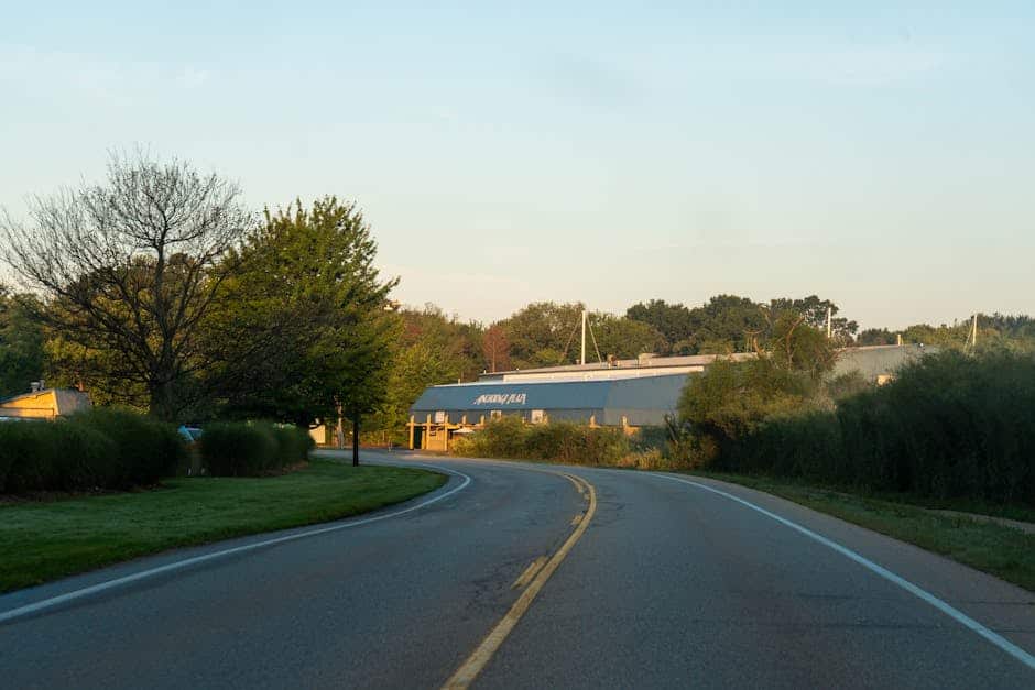 Serene evening view of a winding road leading to a building with natural surroundings in Holland, Michigan.